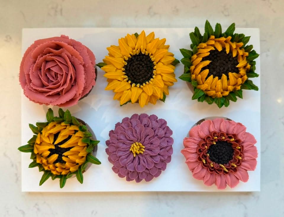 A box of six with a dusty rose, sunflowers, a plum zinnia and a pink gerbera daisy