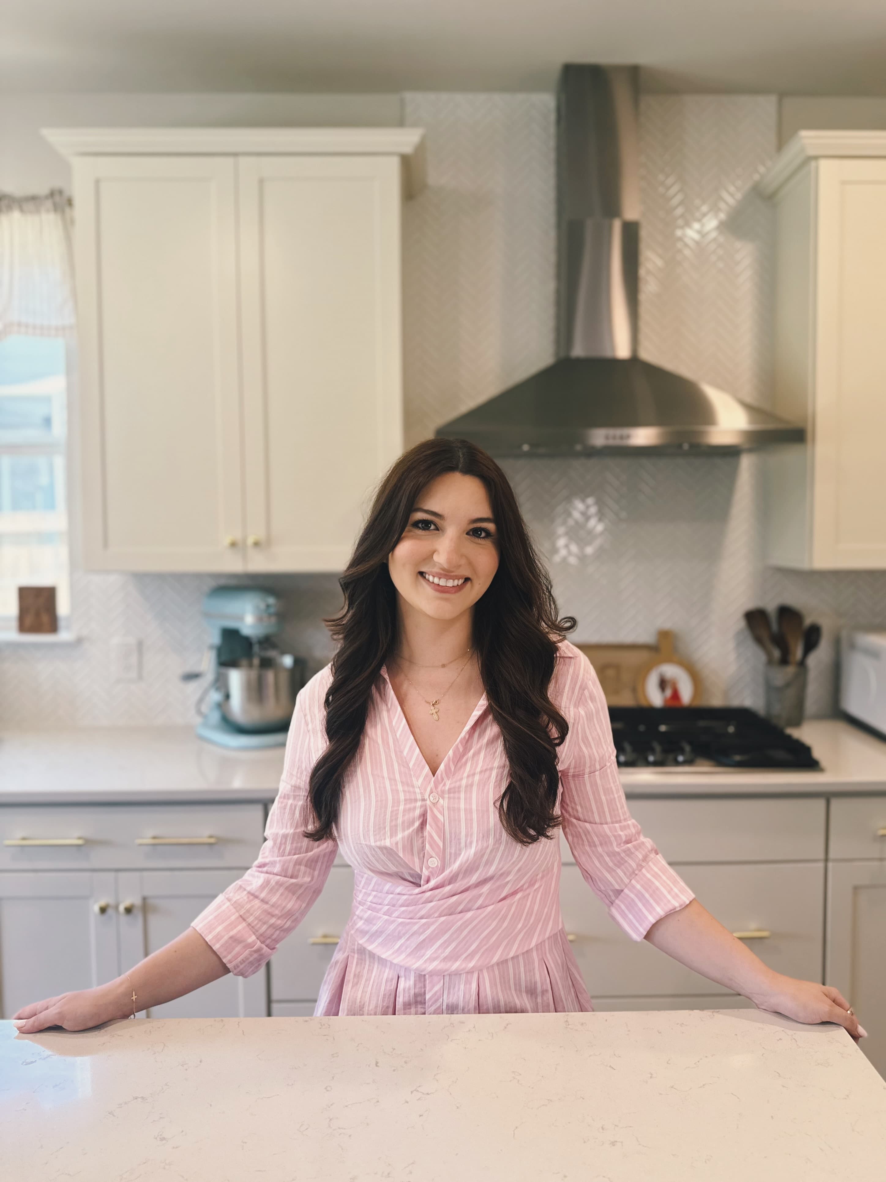 Sonya, the baker behind The Petal Patisserie, smiling in her kitchen